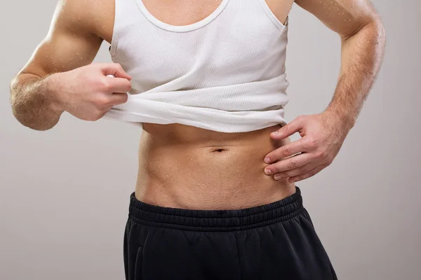 Fit gutaussehender Kerl im weißen Hemd, der seinen Bauch zeigt — Stockfoto