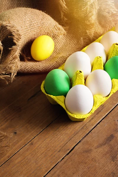 Easter eggs in yellow carton with jute decoration — Stock Photo, Image