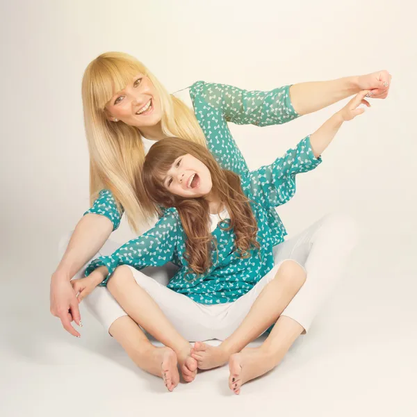 Mother and daughter hug sitting wearing matching outfit — Stock Photo, Image
