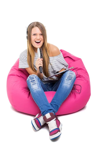 Cute teenage girl singing karaoke with hair brush microphone — Stock Photo, Image