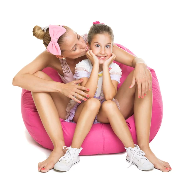 Young mother and daughter sitting on pink bean bag — Stock Photo, Image