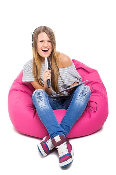 Linda adolescente cantando karaoke con micrófono de cepillo de pelo Imágenes de stock libres de derechos