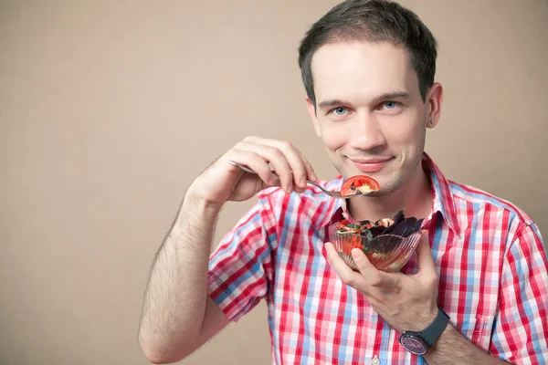 Menino bonito magro comendo salada sobre fundo de madeira. Retrato com espaço de cópia. estúdio tiro — Fotografia de Stock