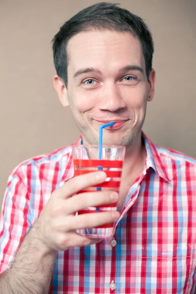 Fröhlich nachdenklicher blauäugiger Hipster-Junge, der vor hölzernem Hintergrund trinkt — Stockfoto