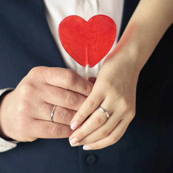 Loving hands holding sweet red heart — Stock Photo, Image