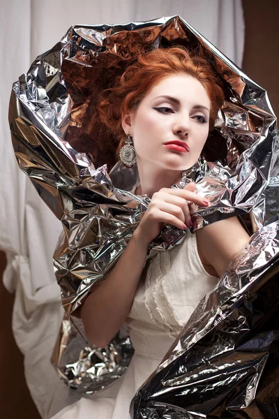 Arty portrait of a fashionable queen-like model with silver foil — Stock Photo, Image