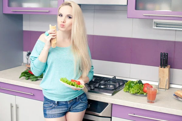 Schöne junge schwangere Frau genießt frisches Brot und Salat in h — Stockfoto