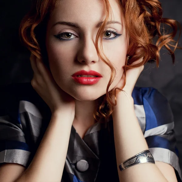 A beautiful young red-haired model in an arty jacket with metal — Stock Photo, Image
