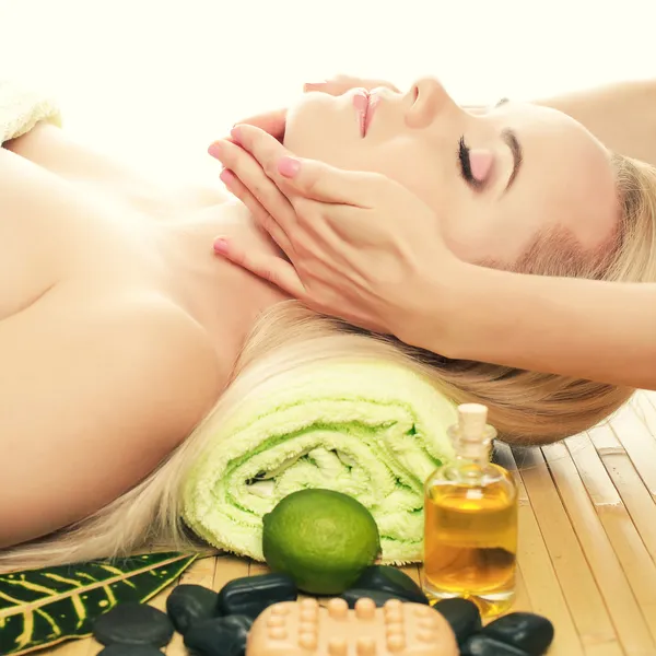 Une belle jeune femme reçoit un massage facial dans un salon de spa . — Photo