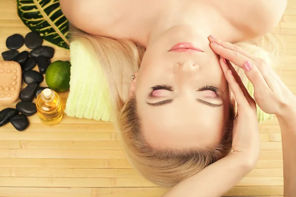 Una hermosa joven recibiendo masaje facial en un salón de spa . —  Fotos de Stock
