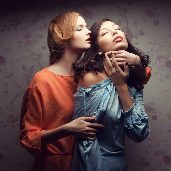 Portrait of two gorgeous girlfriends in blue and orange dresses — Stock Photo, Image