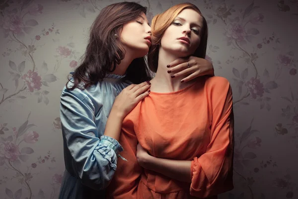 Portrait of two gorgeous girlfriends in blue and orange dresses — Stock Photo, Image