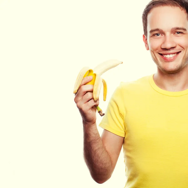Portret van een glimlachende knappe jongen houdt gele bananen over li — Stockfoto