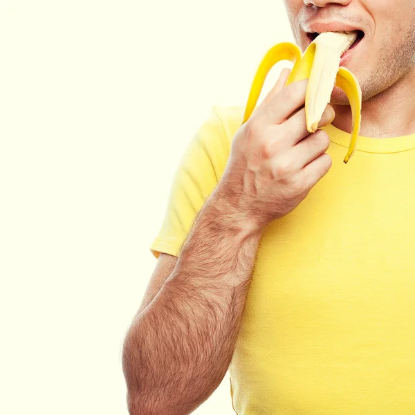Portrait of a smiling handsome guy holding and biting (eating) y — Stock Photo, Image