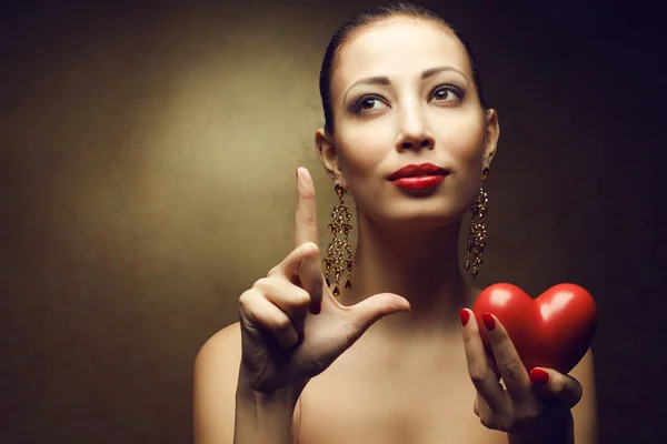 Retrato de um modelo elegante com lábios vermelhos sexy segurando h vermelho — Fotografia de Stock