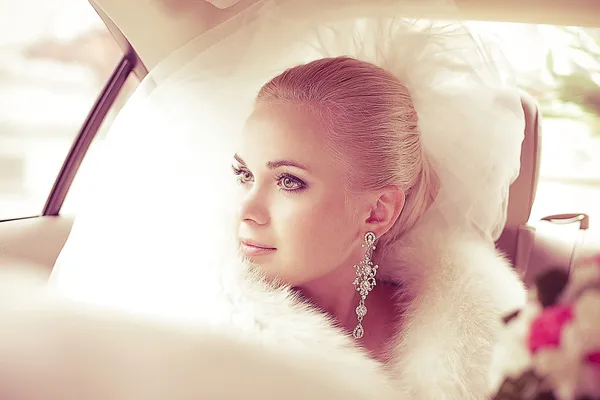 Retrato de uma linda noiva loira sentada no carro de casamento — Fotografia de Stock