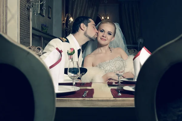 Portrait of kissing bride and groom sitting in a luxurious vinta — Stock Photo, Image