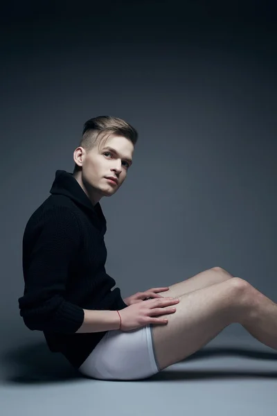 Portrait of a young fashionable man in trendy clothes sitting ov — Stock Photo, Image