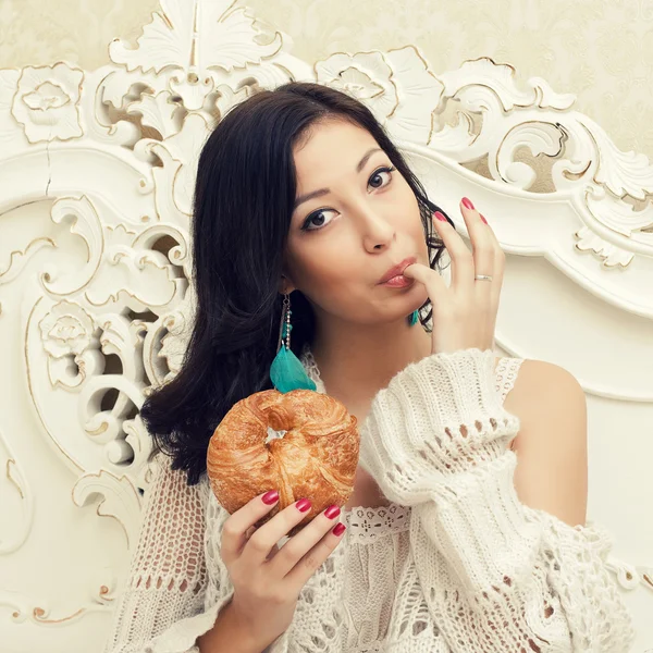 Portrait of a young beautiful woman having breakfast (eating cro — Stock Photo, Image