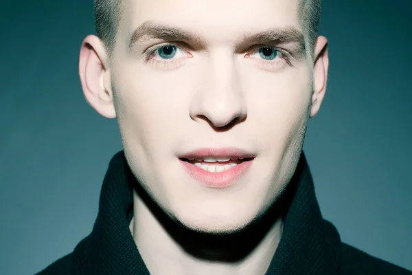 Retrato de un hombre guapo de moda posando sobre bac azul oscuro — Foto de Stock