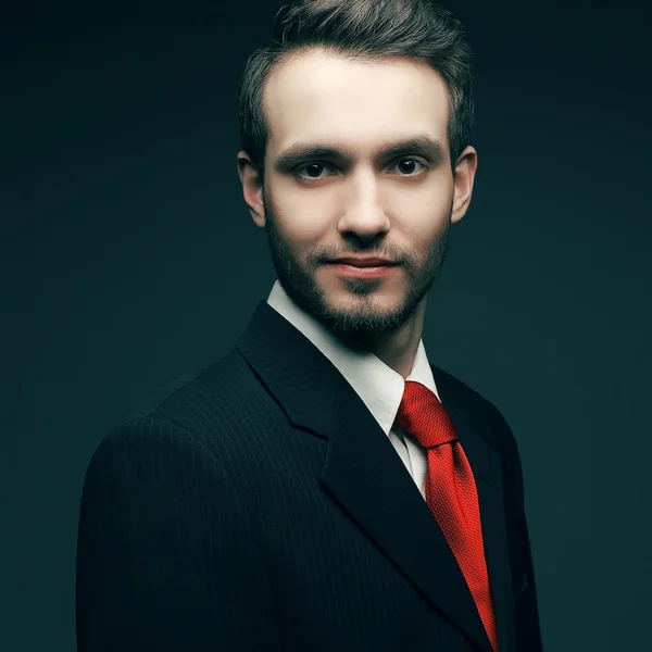 Retrato de um jovem bonito (homem de negócios) em terno preto sagacidade — Fotografia de Stock