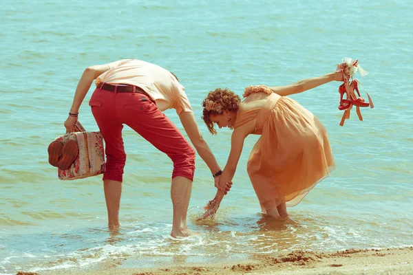 Couple walking on beach. Young happy married hipsters in trendy — Stock Photo, Image