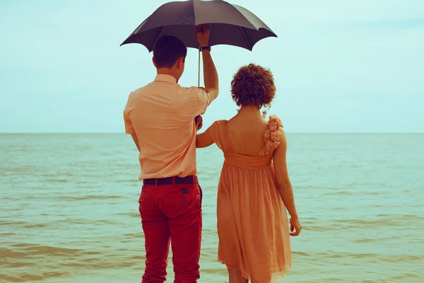 夏の休暇の概念。水の近くのビーチの上に立ってのカップルと — ストック写真