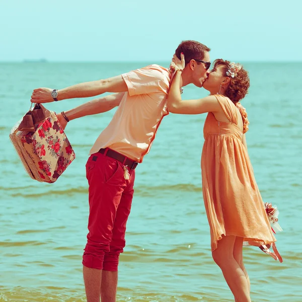 沙滩上散步的情侣。快乐的年轻人结婚时尚及膝 — 图库照片