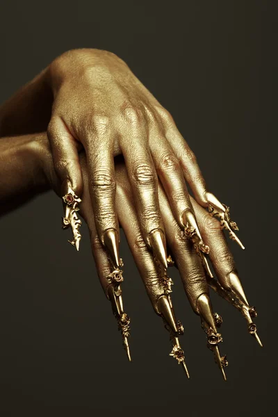 Τέχνη έννοια μανικιούρ. όμορφη χρυσή χέρια με χρυσή μακρά ar — Φωτογραφία Αρχείου
