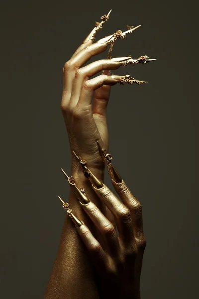 Conceito de Manicure de Arte. Belas mãos douradas com ar longo dourado — Fotografia de Stock