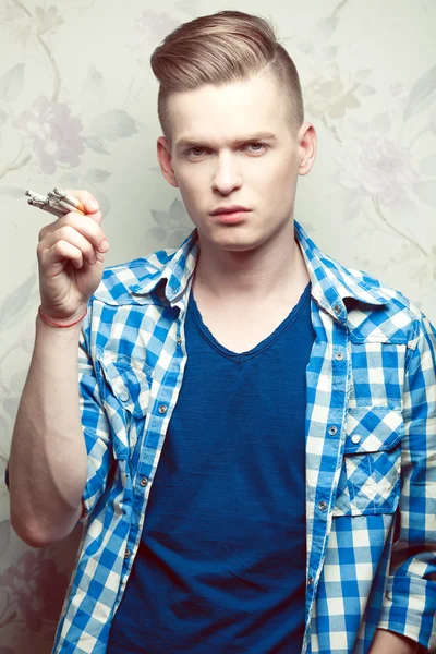 Emotive portrait of a young fashionable hipster boy smoking too — Stock Photo, Image