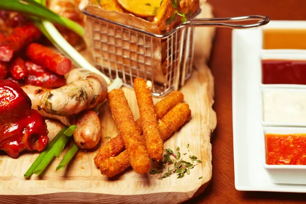 Fried cheese sticks with small meat sausages served with scallio — Stock Photo, Image