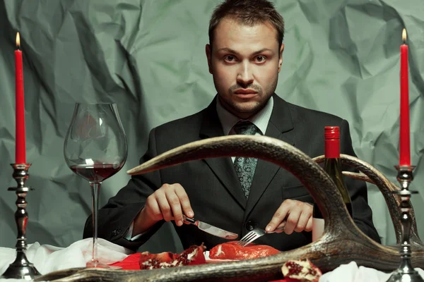 Conceito de jantar barroco. Retrato de homem bonito comendo carne — Fotografia de Stock