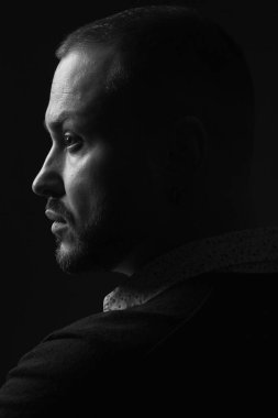 Her yaşta müthiştir. Siyah arka planda duran 40 yaşındaki karizmatik bir adamın portresi. Kısa saç kesimi. Klasik, akıllı gündelik tarz. Kapatın. Siyah beyaz stüdyo çekimi