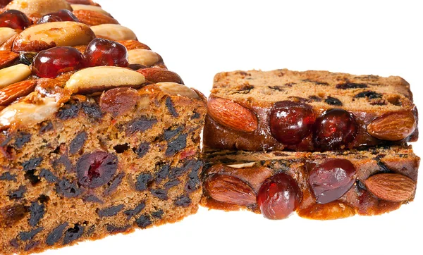 Rebanadas de pastel de frutas de Navidad con almendras de cerezas y nueces de Brasil . — Foto de Stock