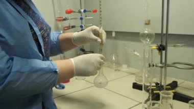 Bilim adamı pembe sıvı üzerinde bir deney yapıyor. Bir laboratuvar. Laboratuvar araştırması.