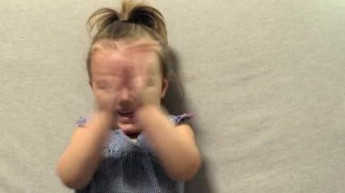 Gülümseyen ve el çırpan bir kız. Yakın plan..