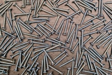 Masada bir sürü gümüş metal vida var. Yakın plan, arka plan..
