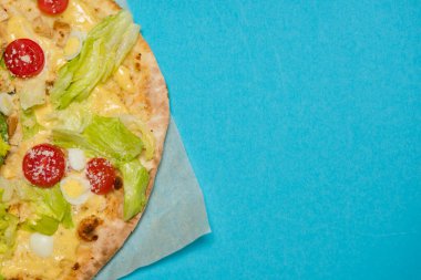 Açık mavi arka planda nefis sıcak pizzaya yakın çekim. Seçici odaklanma. Üst Manzara. Metin için boşluk.