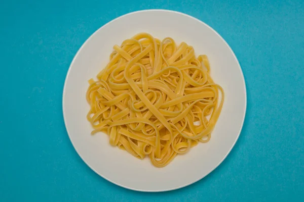 Pasta Espaguetis Sobre Plato Blanco Sobre Fondo Azul —  Fotos de Stock