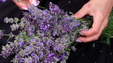 A woman makes a handmade decor from lavender flowers. Close up. Slow motion.