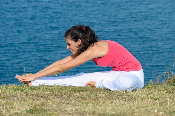 Stretching with sea on the background — Stock Photo, Image