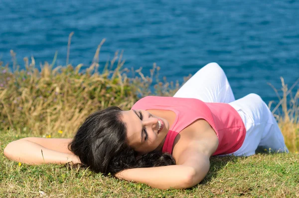 Kvinna avkopplande på sommaren mot havet — Stockfoto