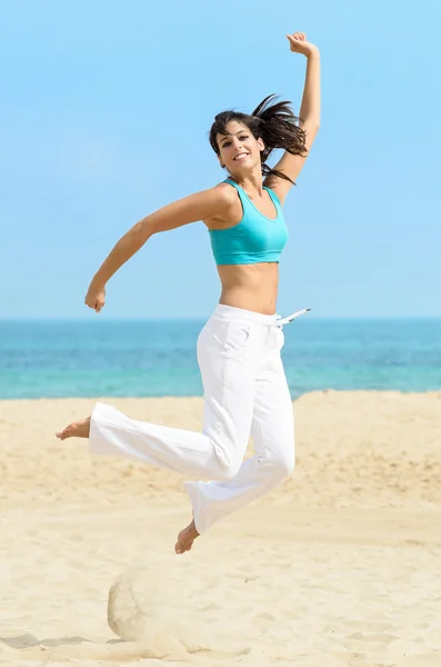 Играющая девушка весело прыгает на пляже — стоковое фото