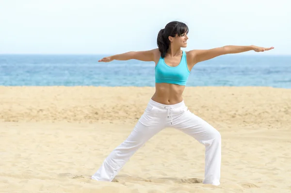 Mujer practicando pilates y yoga en la playa — Foto de Stock