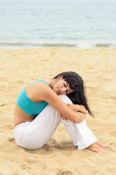 Женщина сидит одна на пляже — стоковое фото