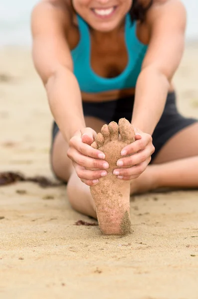 Foten och stretching koncept på stranden — Stockfoto