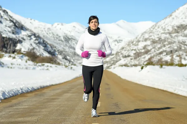 Mujer corriendo en camino de invierno — Foto de Stock