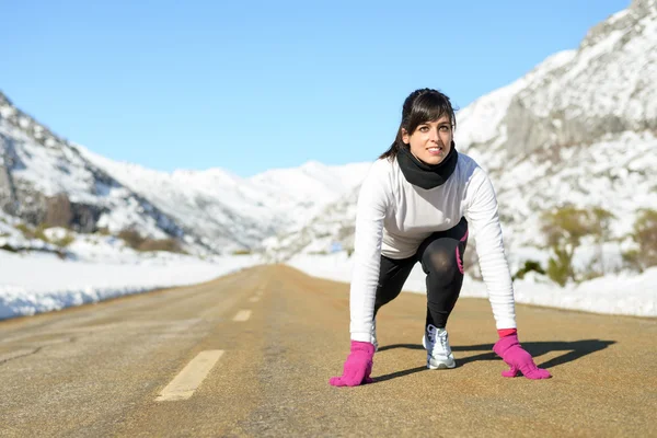 Vrouw uitgevoerd in winter landschap weg — Stockfoto