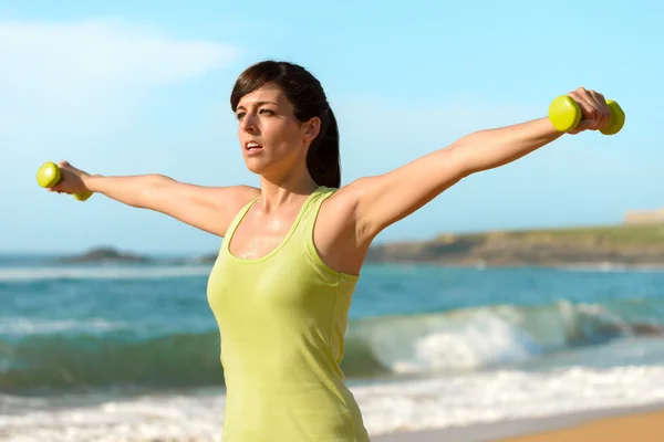 Fitness vrouw uit te werken op strand — Stockfoto